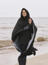 Model wearing a multicolored blue and grey blanket cape, showcasing its silhouette and hood
