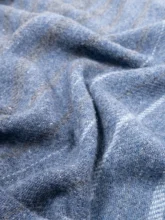 Textured blue recycled wool blanket crumpled to show the soft, fluffy fibers and the plushness of the material.