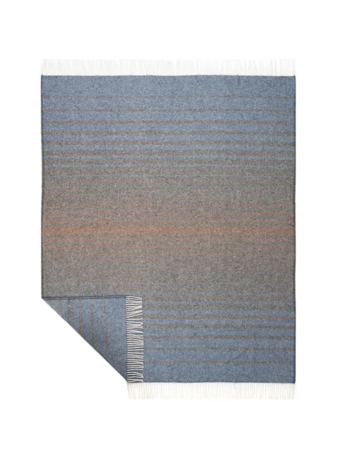 Overhead view of a dark recycled wool blanket laid flat, featuring blue and grey stripes and a neat white fringe, highlighting its quality and design.