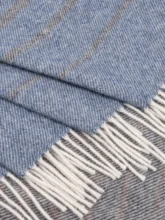 Detailed view of a dark recycled wool blanket with subtle blue stripes, focusing on the texture and fringed edge.